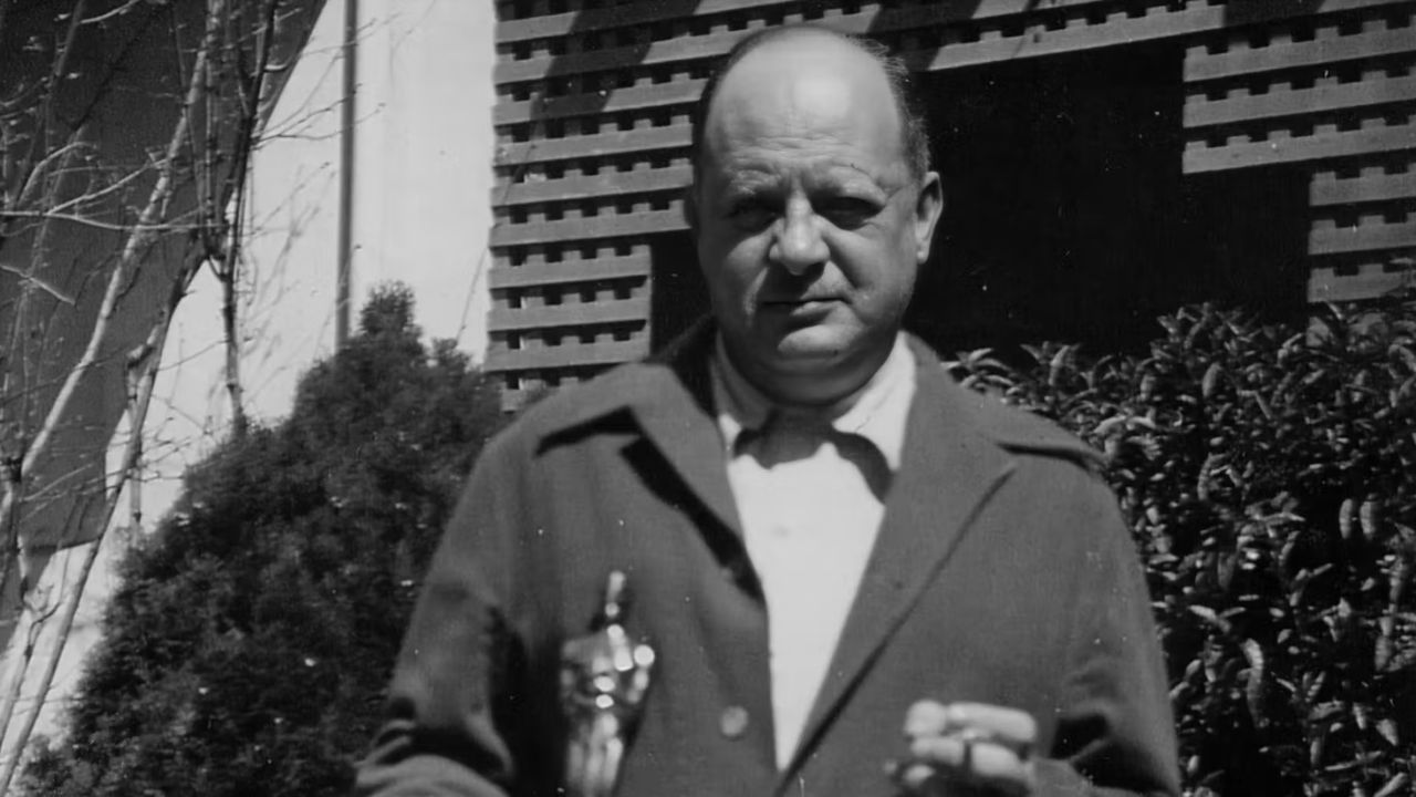 a man looking at the camera with an Oscar statuett